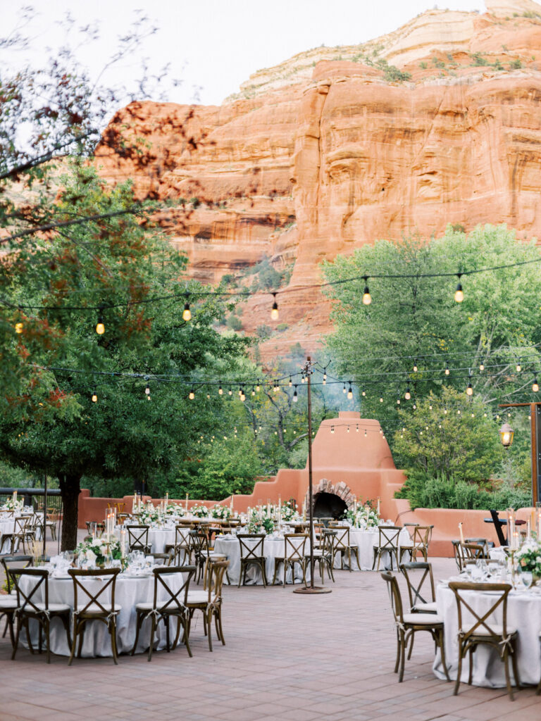 Wedding reception tables under string lights beneath the red rock walls of Boynton Canyon at Enchantment Resort
