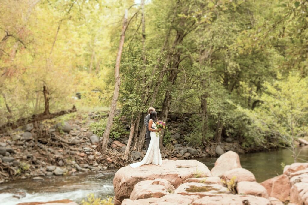 Bride and groom on the red rocks along Oak Creek at L Auberge de Sedona