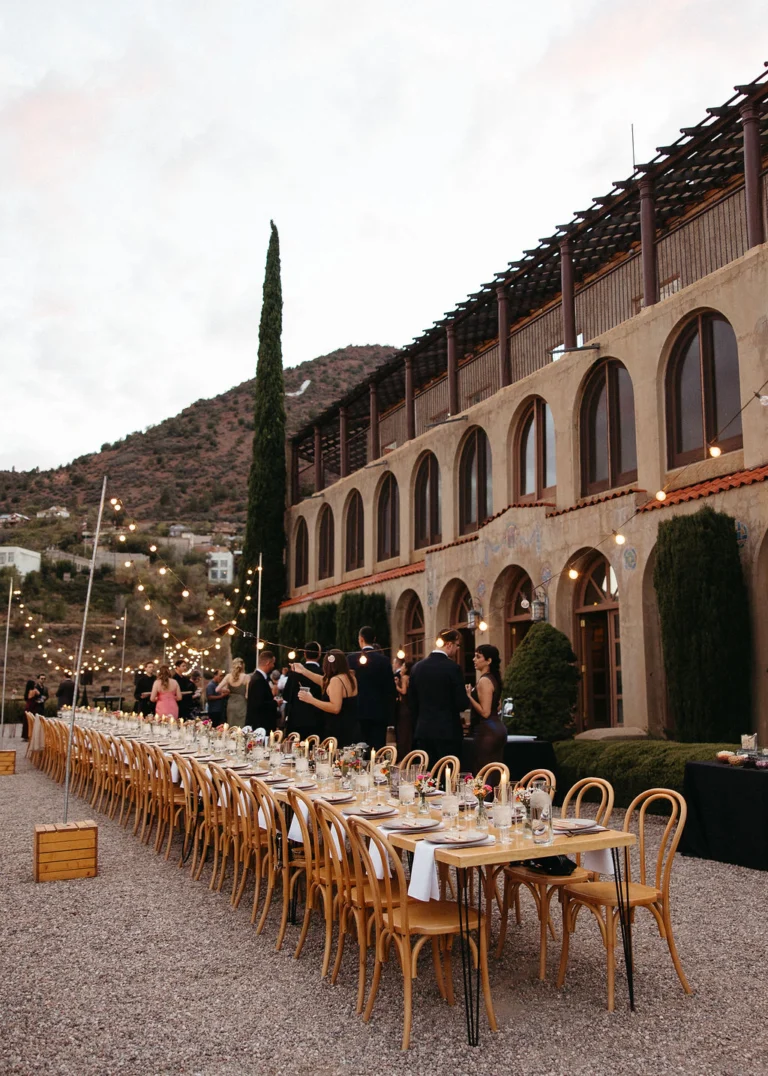 Long reception table under string lights beside the historic Little Daisy estate in Jerome at dusk