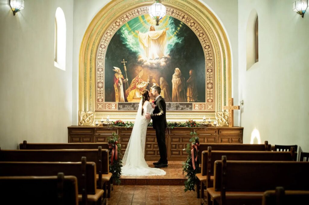 Bride and groom sharing a kiss at the altar of the Tlaquepaque Chapel in Sedona
